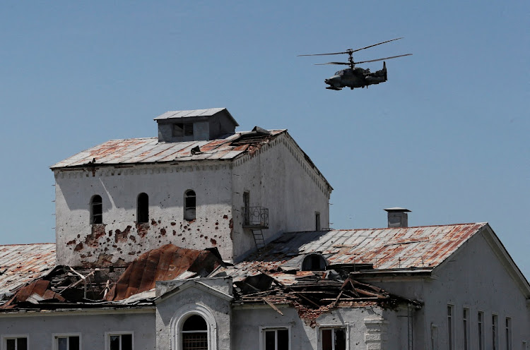 A Russian Ka-52 attack helicopter flies near a heavily damaged building in the town of Popasna, in the Luhansk region, Ukraine, June 2 2022. Picture: ALEXANDER ERMOCHENKO/REUTERS