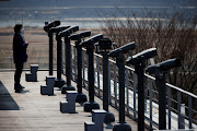 A woman looks toward the north at an observatory platform near the demilitarized zone separating the two Koreas in Paju, South Korea on March 24, 2021.   