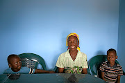 Sara Machava, the mother of Emmanuel Sithole who was murdered in Alexandra on April 18 2015, in the new brick house built in Nhachunga village in Mozambique's Sofala province with funds raised by the Sunday Times. With her are her grandsons, Sithole's sons Jeremia, 5, and Jossia, 7. 