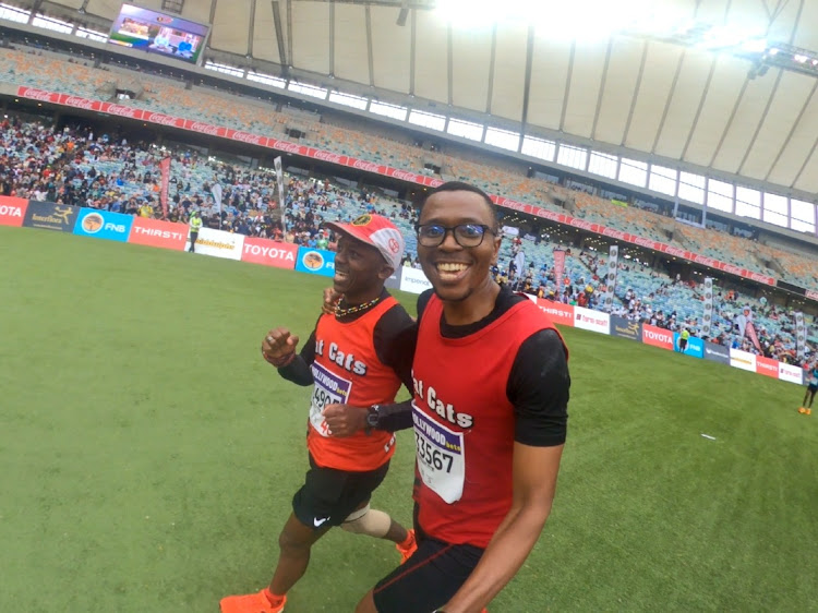 Thulani Mbele finishing the Comrades Marathon at Moses Mabhida stadium with a friend Lehlohonolo Moate.