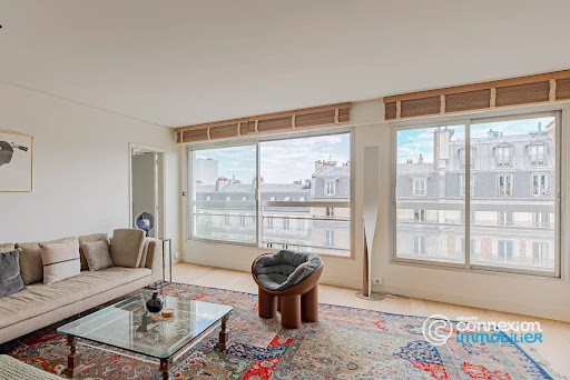 Bright living room with panoramic city view in this luxury property for sale in Paris 16ème ($2,125,374 - 107 m²)