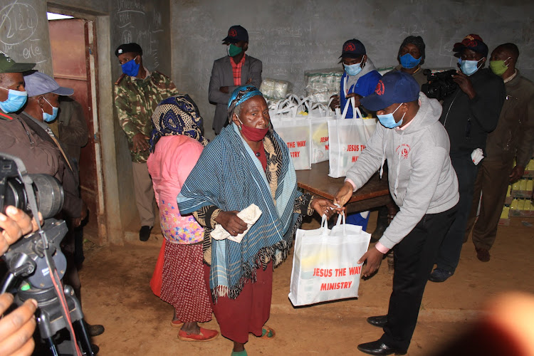 Jesus The Way Ministry's pastor Joseph Chege issuing foodstuffs at Mununga in Kigumo, Murang'a, on Saturday.