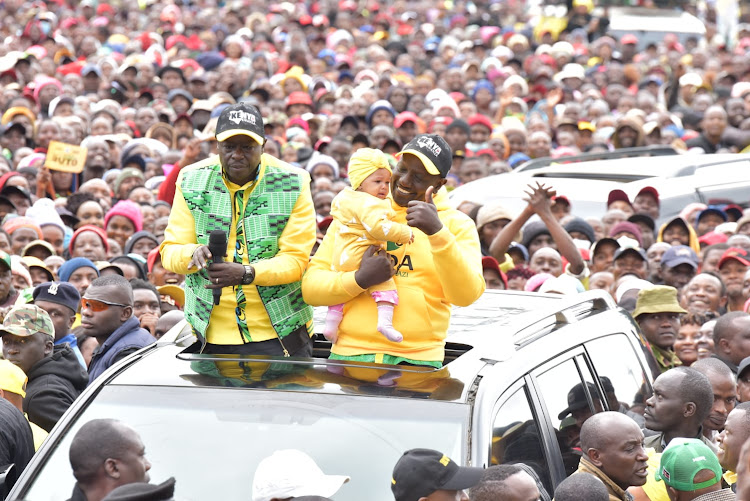 DP William Ruto holds a baby on Wednesday during his final political rally at Kerugoya stadium.