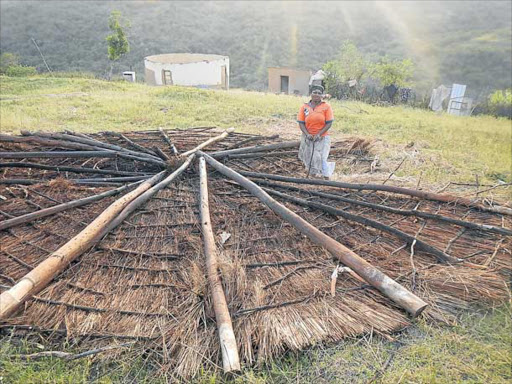 LEFT HOMELESS: Port St John's resident, Neliswa Qumrhana, stands next to grass thatching blown off the roof of her home in a freakish hailstorm which swept through Buthulu village on Thursday, leaving about eight families homeless and 24 houses damaged Picture: SIKHO NTSHOBANE