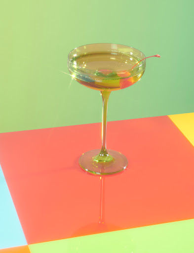 A yellow Estelle Colored Glassware champagne glass on top of a pastel checkered counter.