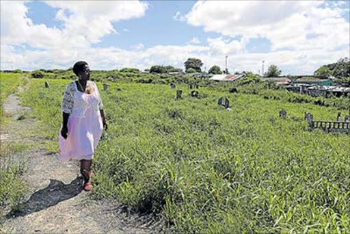 FEBRUARY 24, 2017 Zanele Peta walks amongst graves which are covered by overgrown grass and bush at John Dube Cemetery in Buffalo Flats. Peta is looking for her late mother’s grave which she suspects is hidden under the growth. PICTURE ALAN EASON