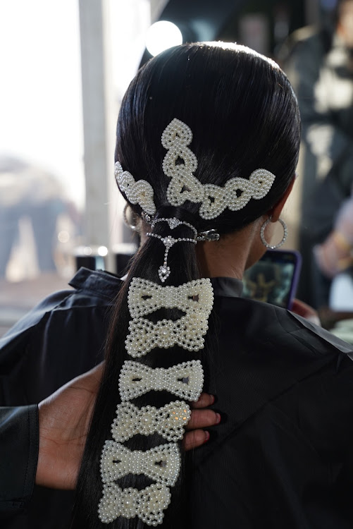 Mimi Mvakali decorating her hair in oversized pearl bows hair clips and glittering jewellery at Durban July in Durban.