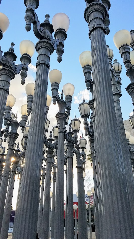 One of the most famous and free (since it is an outdoor sculpture) art you can see in the park at LACMA is the iconic Urban Lights. Created by Chris Burden, it is made of 202 restored street lamps in various styles based on where they were from (most are from southern California and some from Portland Oregon too!). The lamps are painted grey and assembled in a grid, and are solar powered and become lit in the evening.