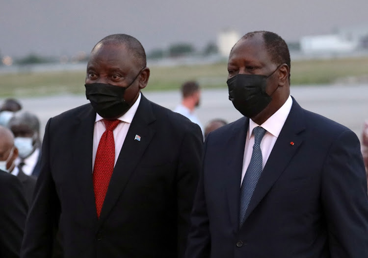 South African President Cyril Ramaphosa walks with Ivory Coast's President Alassane Ouattara at Felix Houphouet Boigny International Airport in Abidjan, Ivory Coast on December 1, 2021.