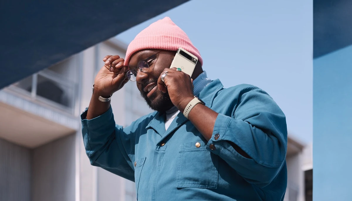 A person holds their Pixel 8 Pro while walking outside.