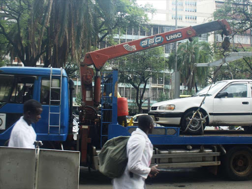 Nairobi county truck carries away a car from a parking slot on Kenyatta Avenue in 2018. /JOSEPH NDUNDA