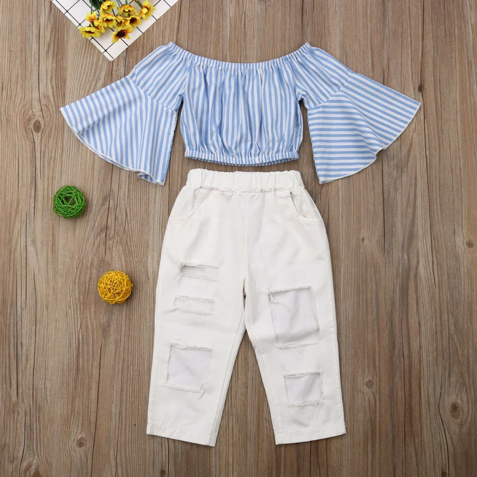 Traje de niña con jeans blancos rasgados y mangas acampanadas, perfecto para un look moderno y fresco. ¡Comodidad y estilo combinados!