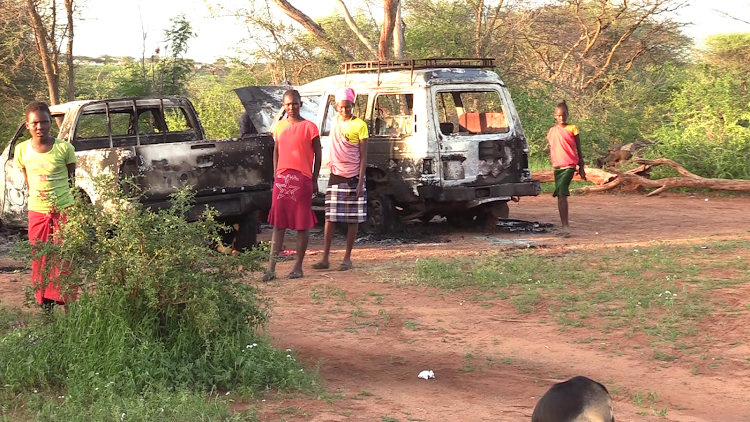 Learners near the vehicles torched by unknown assailants at Olng'arua Primary School and Community Education Centre in Leparua, Isiolo County