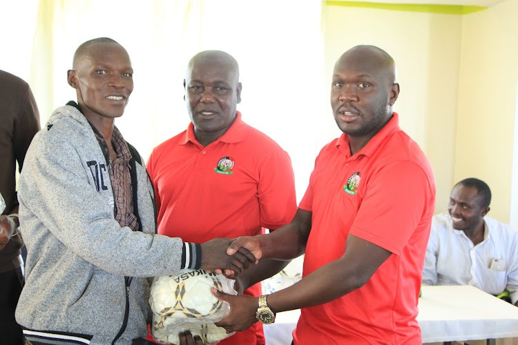 KF Nyanza South chairman Yobesh Mose(C) and Wazito CEO Luthers Mokua donate balls to teams participating in Nyamira County League.