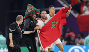 Hakim Ziyech (second right), Jawad El Yamiq (right) and members of the Morocco technical staff celebrate their 2-1 World Cup Group F victory over Canada at Al Thumama Stadium on December 1 2022. Morocco meet Spain in the last-16 on Tuesday.