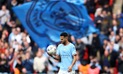 Manchester City's Riyad Mahrez celebrates with his hat-trick match ball after the match after the FA Cup semifinal against Sheffield United at Wembley Stadium in London on April 22 2023.