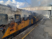 A firefighter douses the flames from a train fire in Cape Town.