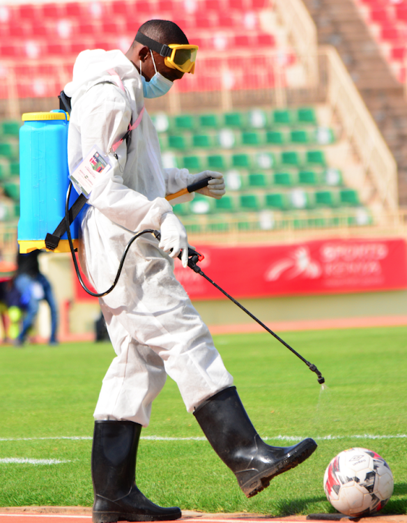 A Medical personnel sanitizes one of the matchballs during a friendly match between Harambee Stars and Zambia at Nyayo Stadium