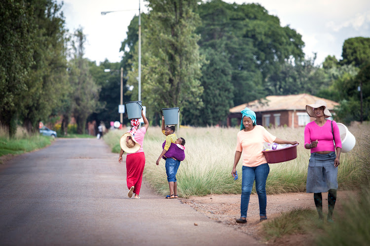 The residents of Blyvoor village near Carletonville with buckets to get water from the water truck.