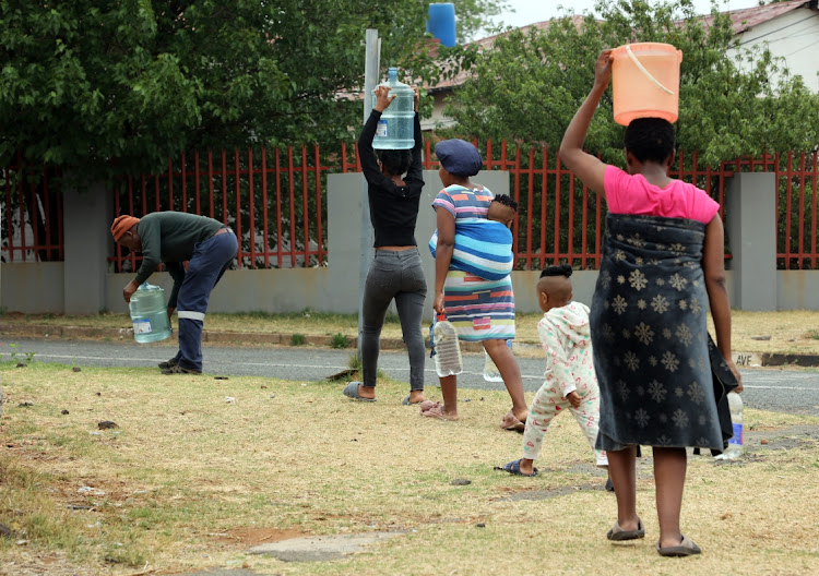 South Hills residents carry water to their residences after collecting it from tankers.