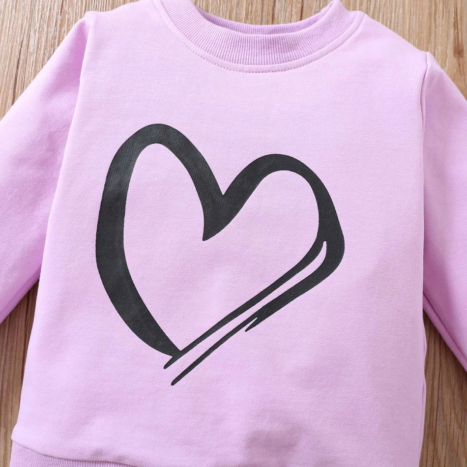 Ensemble deux pièces pour enfants avec imprimé cœur. Confortable et tendance, idéal pour jouer et sortir. Parfait pour un look adorable au quotidien.