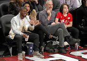 Comedians Kevin Hart, left, and Jon Stewart, centre, watch an NBA all-star game in Toronto, Canada.