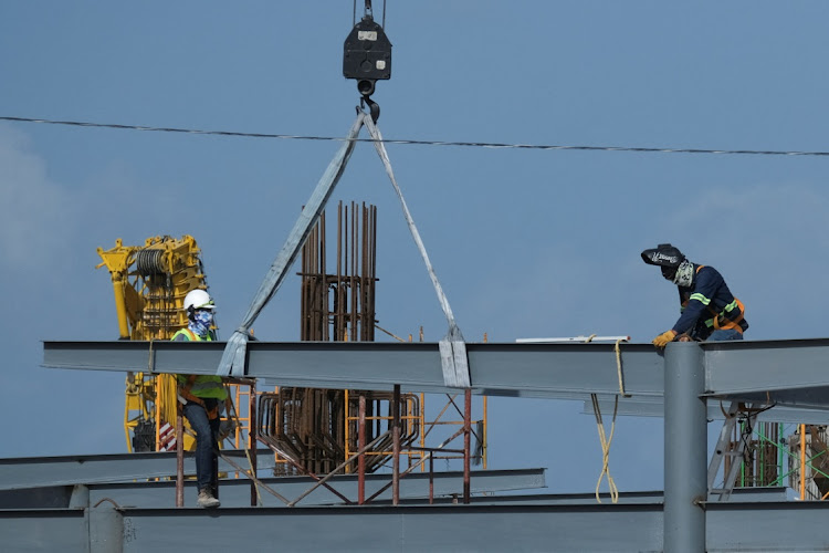 Workers at the site of the ongoing construction of the Cancun Mayan train station in Cancun, Mexico. In SA such major projects are habitually disrupted by extortion mafia gangs.