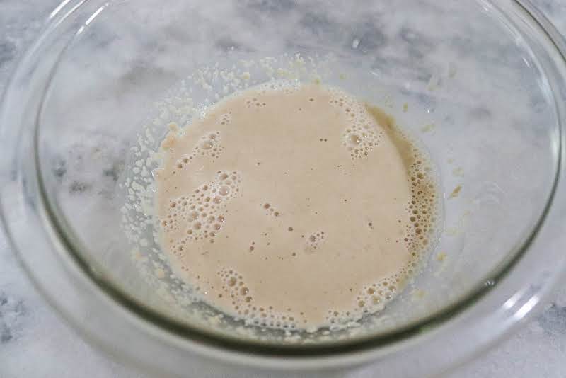 Dissolving Yeast In A Bowl Of Warm Water.