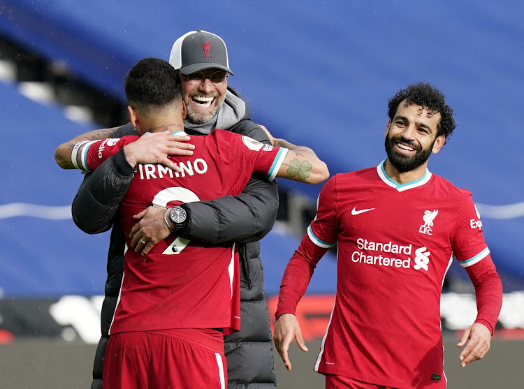 Liverpool's Roberto Firmino celebrates with manager Jurgen Klopp after the match as Mohamed Salah looks on after beating West Brom over the weekend