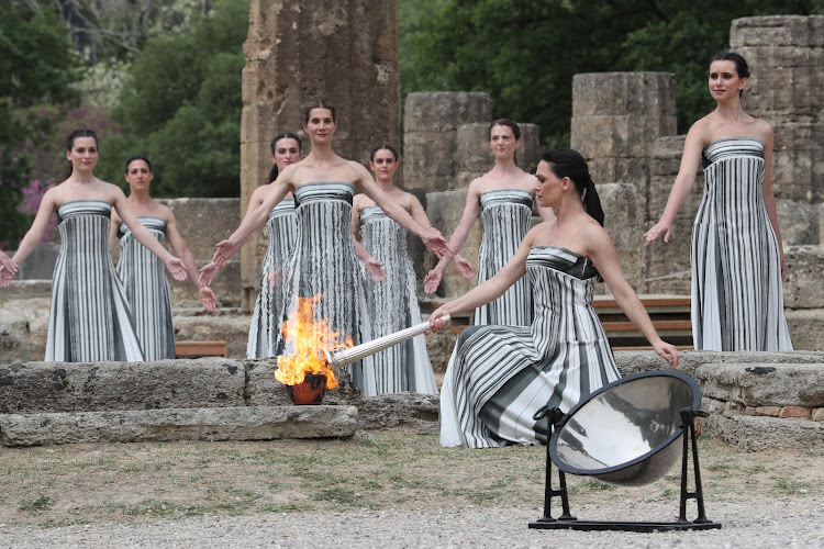 Actress Mary Mina, in the role of High Priestess, lights the torch during the Olympic flame lighting ceremony for the Paris 2024 Summer Olympic Games in Ancient Olympia, Greece, on April 16