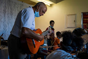 Music teacher Peter van Wyk and some of the children involved in Join Bands, Not Gangs in Scottsville, Kraaifontein.