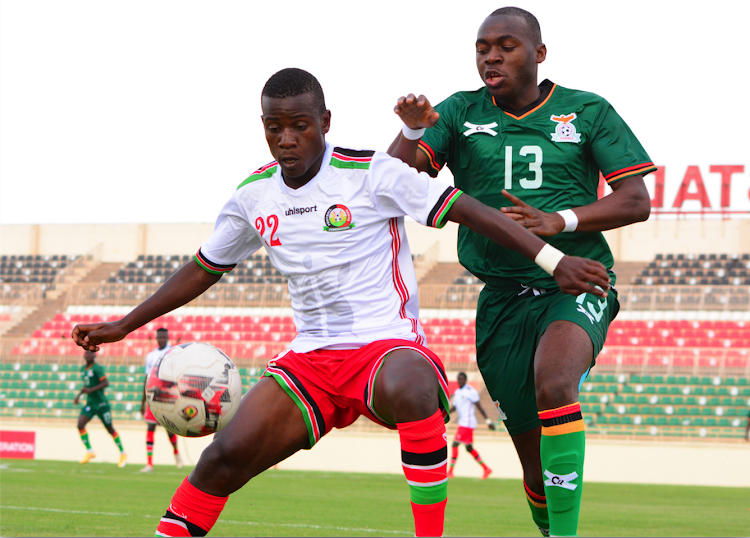 Harambee Stars' defender David Owino shields the ball from Godfrey Nawenya of Zambia during their International friendly match at Nyayo Stadium.