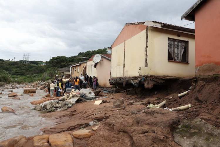 President Cyril Ramaphosa inspects where Mabel Gwala lived in an outside building at the back of a main house. The building was swept away by the river and Gwala is missing.