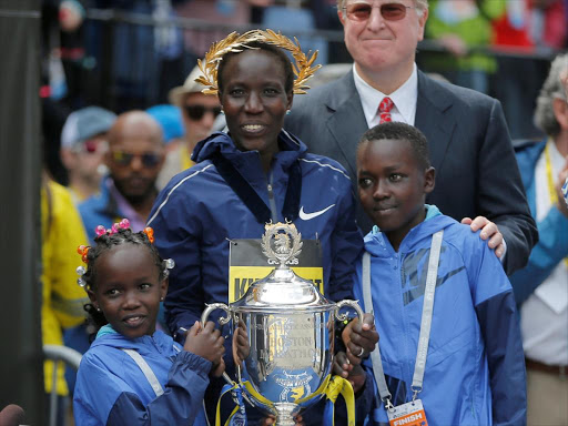 Edna Kiplagat of Kenya poses with her children Wendy and Carlos after winning the women’s division of the 121st Boston Marathon in Boston, Massachusetts, U.S., April 17, /REUTERS