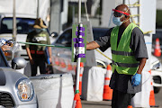 A worker deposits a novel coronavirus test in a barrel in Los Angeles, California, US, December 1, 2020.