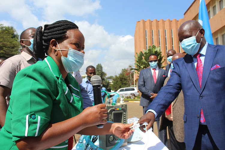 Rhoda Njeri, a training officer from Jhpiego, checks Nyeri Covernor Mutahi Kahiga’s oxygen circulation level in Nyeri town on Thursday