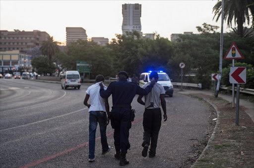 A police officer arrests two men during clashes between students and police in front of the Union Building on October 23, 2015 in Pretoria. South African police on October 23 fired rubber bullets and tear gas at students protesting outside government headquarters over hikes to university fees that President Jacob Zuma was forced to scrap after days of unrest. Zuma had been due to address the volatile crowd of thousands after talks with student leaders and university officials inside the buildings, but instead he read a short statement at a televised press briefing. "We agreed that there will be a zero increase of university fees in 2016," he said.