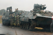 Soldiers stand beside military vehicles just outside Harare, Zimbabwe, November 14,2017. 