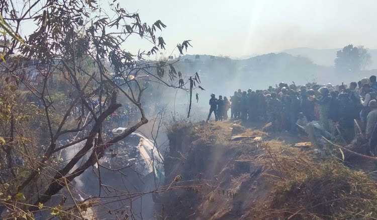 Crowds gather at the crash site of an aircraft carrying 72 people in Pokhara in western Nepal on January 15 2023.