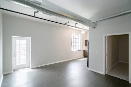 View of Living/Kitchen area featuring French door leading to balcony, large picture window in kitchen, open door to bedroom