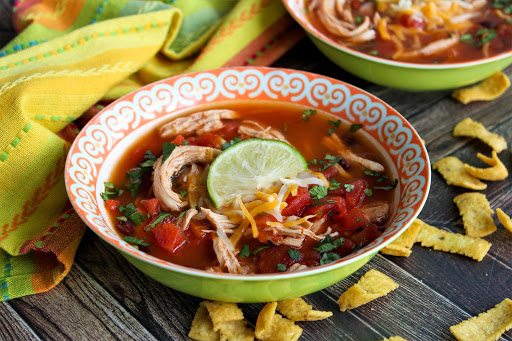 A bowl of Easy Chicken Taco Soup with a lime wedge.