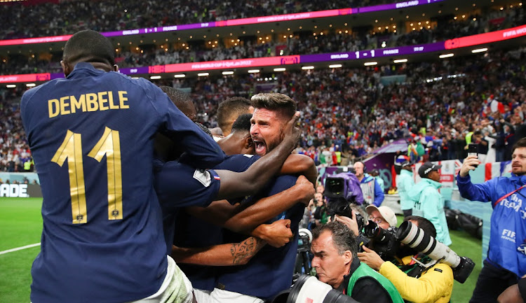 Olivier Giroud of France celebrates scoring the winning goal with teammates in front of photographers in their World Cup quarterfinal win against England at Al Bayt Stadium in Al Khor, Qatar on December 10 2022.