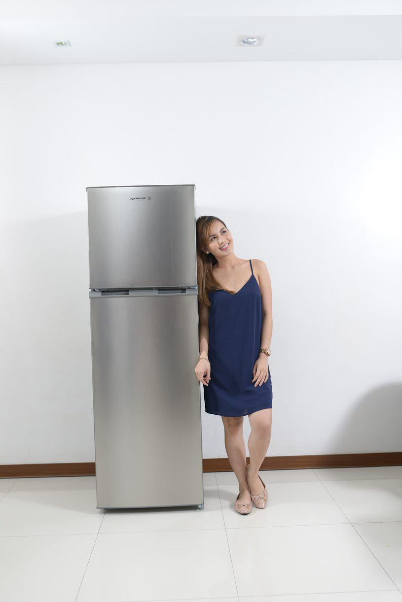 A person standing in front of a refrigerator

Description automatically generated