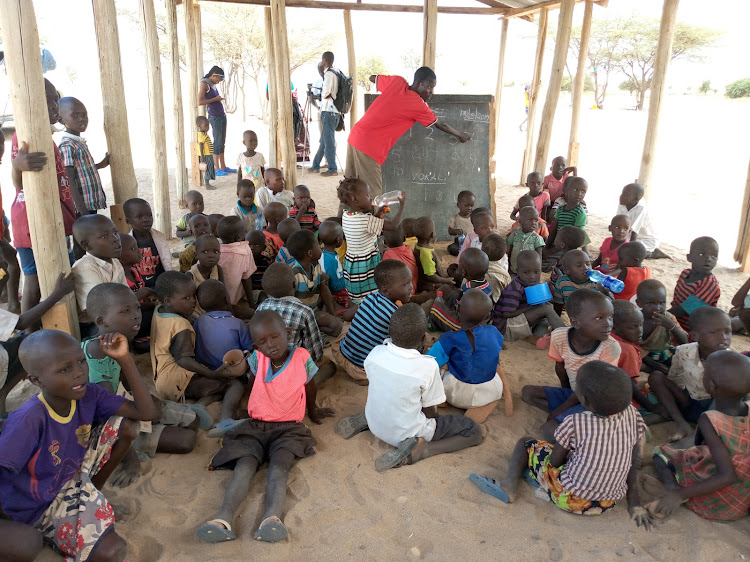 Pupils of Lobolo Pprimary school in Turkana sit on the ground in uncompleted classroom.