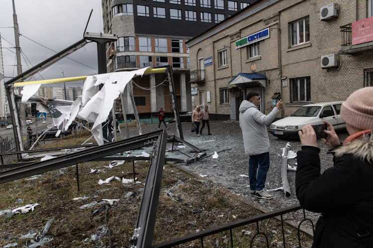 People take photos of damage caused by a rocket in Kyiv, Ukraine. Overnight, Russia began a large-scale attack on Ukraine, with explosions reported in multiple cities. Picture: GETTY IMAGES /CHRIS MCGRATH