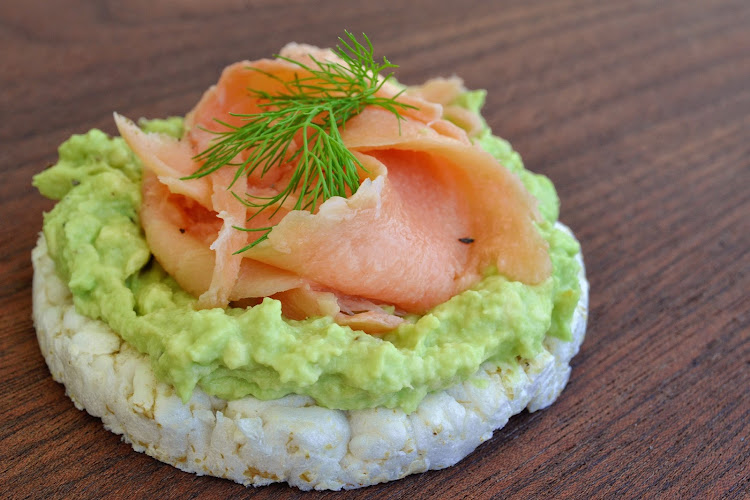 Rice cake topped with avocado spread and tuna