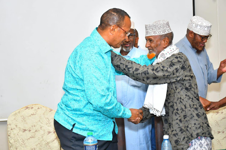 Former Garissa governor Nathif Jama shares a word with the Samawadhal community Ugaas Hassan Shurie at a Garissa hotel on Sunday, March 27.