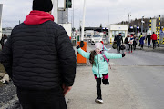 A young Ukrainian girl runs to her father as she exits the border crossing with her siblings and mother after they fled the Russian invasion in Ukraine, in Medyka, Poland.