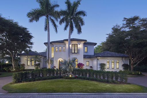 White villa with palm trees and garden in this luxury property for sale in Naples ($4,999,000)