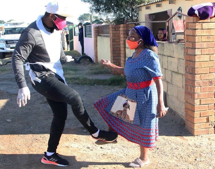 Springbok rugby captain Siya Kolisi greets Nomsa Ngqezana, 70, a member of one of the families that received food parcels and blankets from the Kolisi Foundation and 67 Blankets on May 2